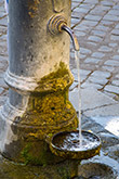 Fontanella con una vaschetta di ghisa sotto al getto dell'acqua
